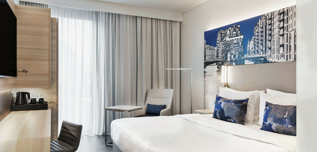 Ein modern eingerichtetes Hotelzimmer in blau-weiß-Tönen gehalten