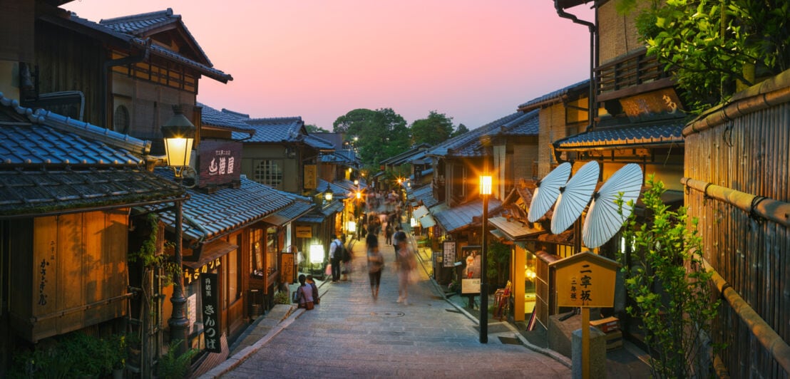 Belebte Gasse in der Altstadt von Kyoto bei Abenddämmerung