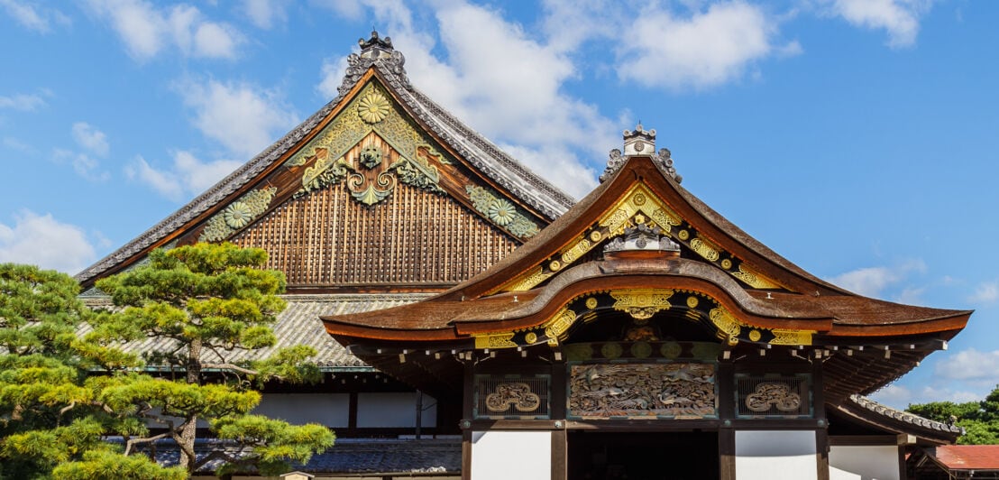 Nahaufnahme von zwei japanischen Tempeldächern aus Holz mit verzierten Giebeln