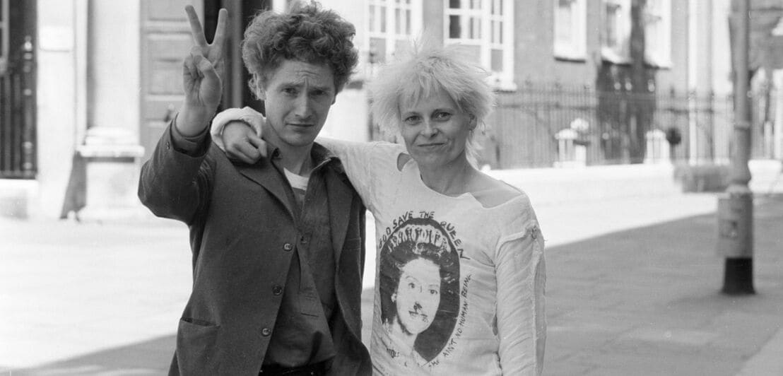 Das Schwarz-Weiß-Bild zeigt Vivienne Westwood und Malcolm McLaren Arm in Arm