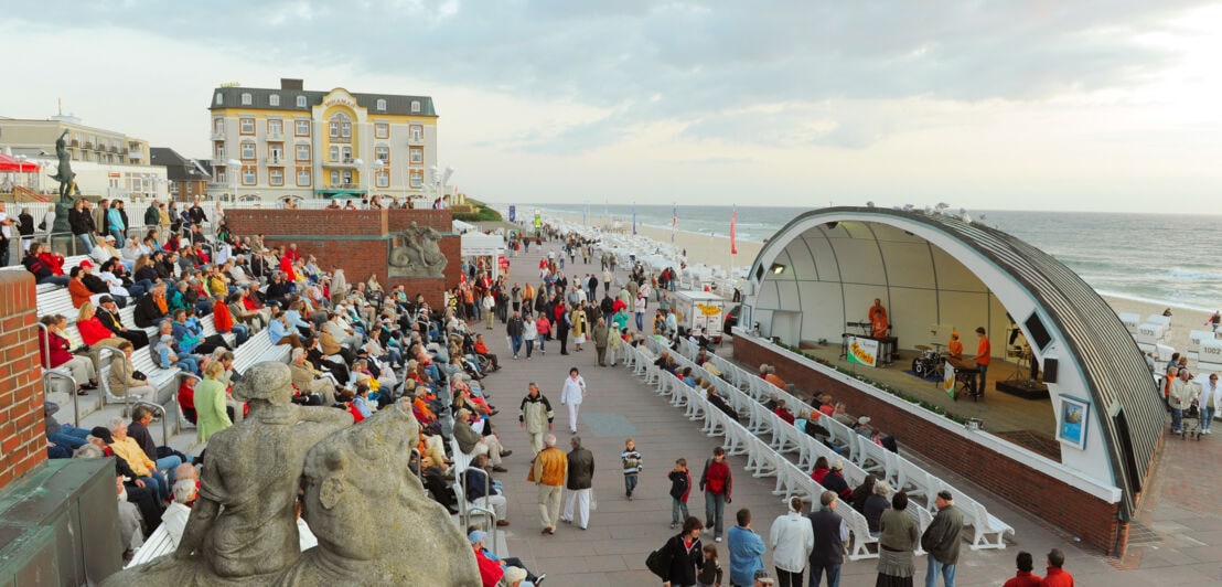 Belebte Strandpromenade von Westerland mit Zuschauern eines Konzertes in einer Musikmuschel