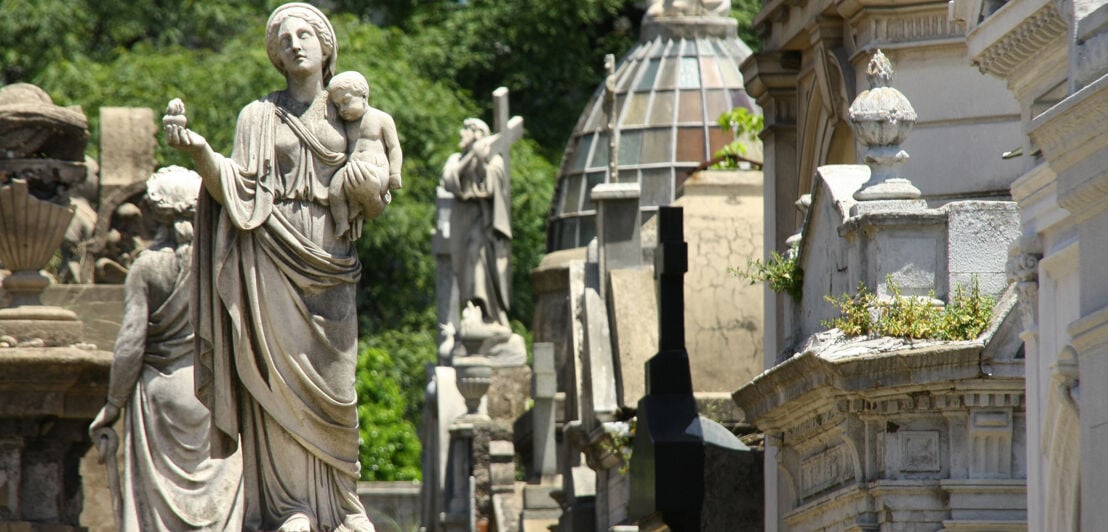 Verzierte Mausoleen mit Steinstatuen auf einem Friedhof