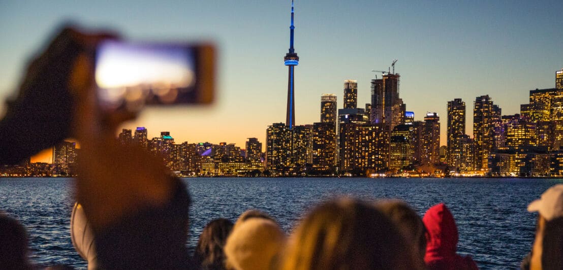 Menschen fotografieren die Skyline von Toronto bei Nacht