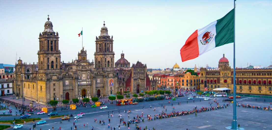 Eine mexikanische Flagge weht vor einer Kathedrale auf dem Hauptplatz von Mexiko-Stadt