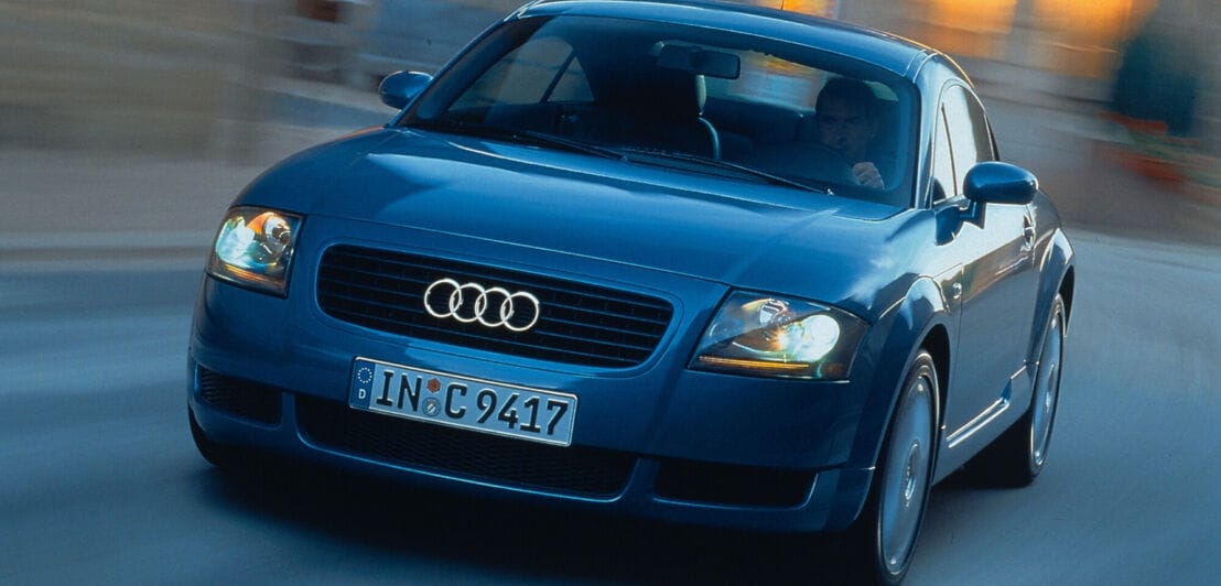 Frontalaufnahme eines fahrenden, dunkelblauen Audi TT Coupé