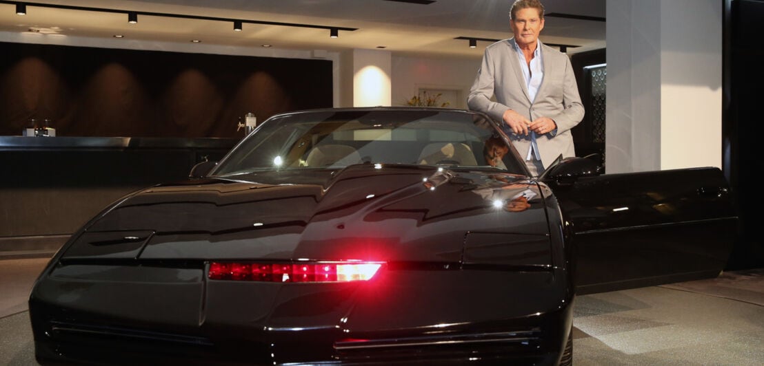 David Hasselhoff posiert mit einem schwarzen Pontiac Firebird Trans Am
