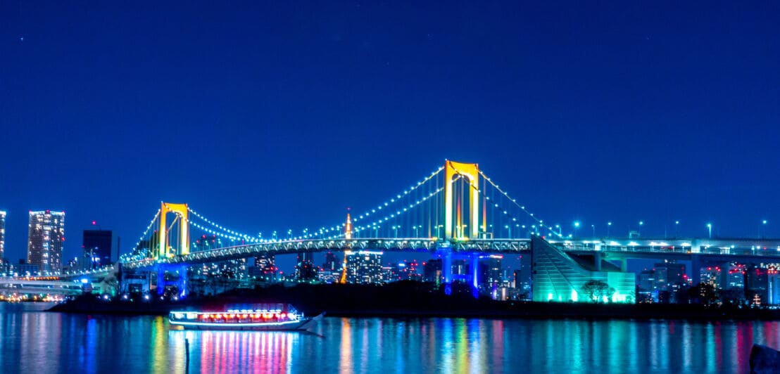 Die Rainbow Bridge in Tokio strahlt in unterschiedlichen Farben