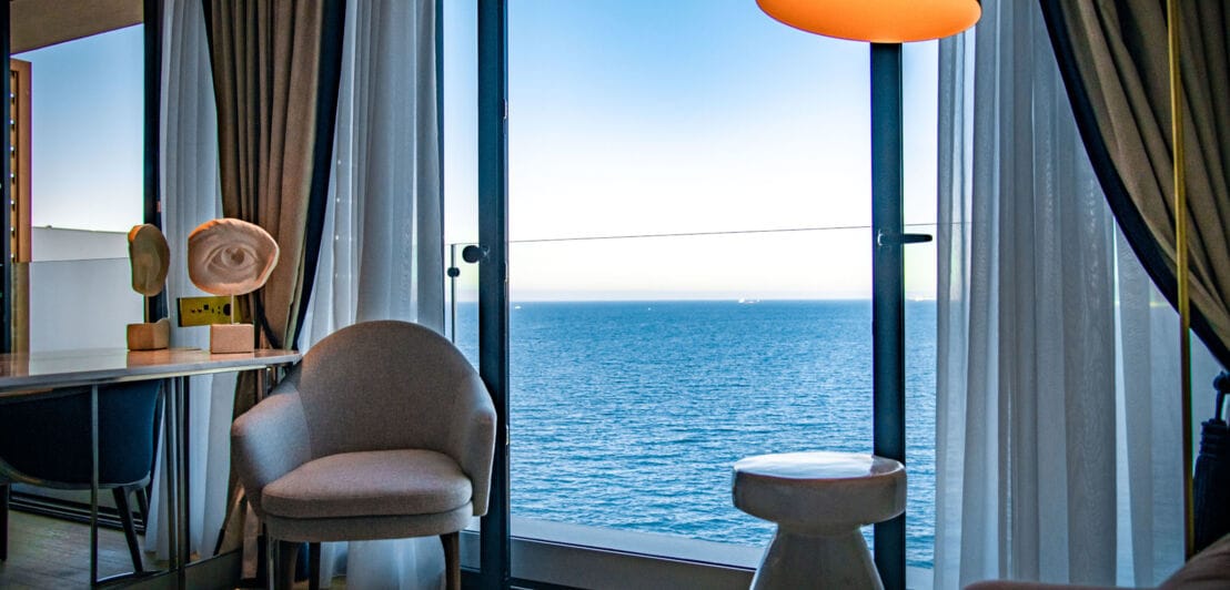 Elegantes Hotelzimmer mit bodentiefem Fenster am Meer