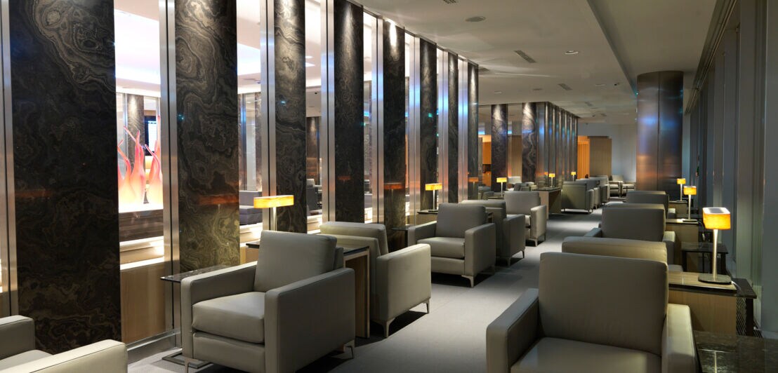 Eine luxuriöse Flughafen-Lounge mit grauen Ledersesseln