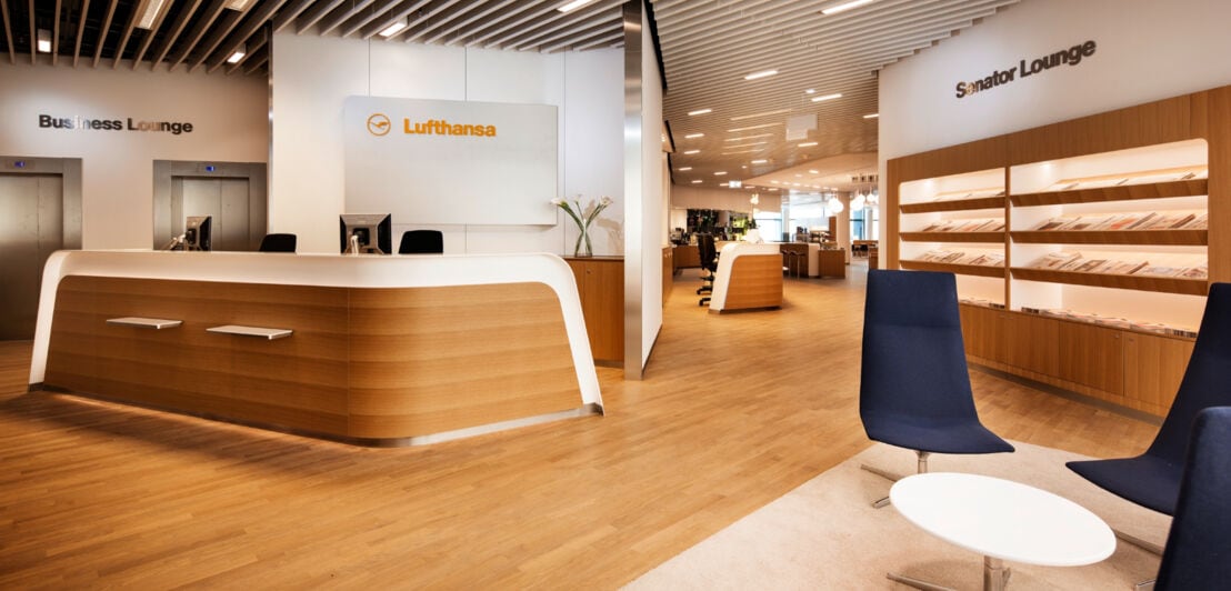 Empfangsbereich einer Lufthansa-Flughafen-Lounge mit Infodesk und Sitzgelegenheiten