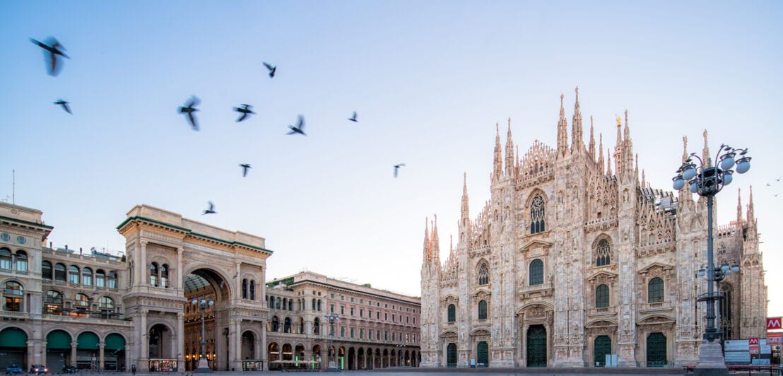 Blick auf den Domplatz in Mailand mit fliegenden Tauen in Vordergrund