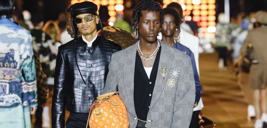 Männliche Models auf einem Laufsteg während einer Modenschau von Louis Vuitton