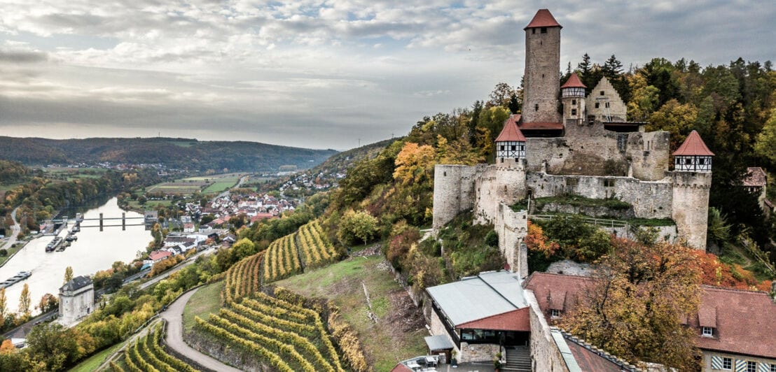 Mittelalterliche Burg mit Terrasse auf einem Weinberg oberhalb eines Flusstals