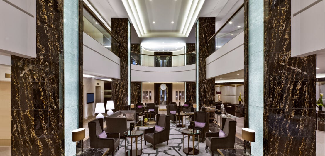 Blick auf einen Loungebereich mit Sesseln und Tischen im Waldorf Astoria Berlin