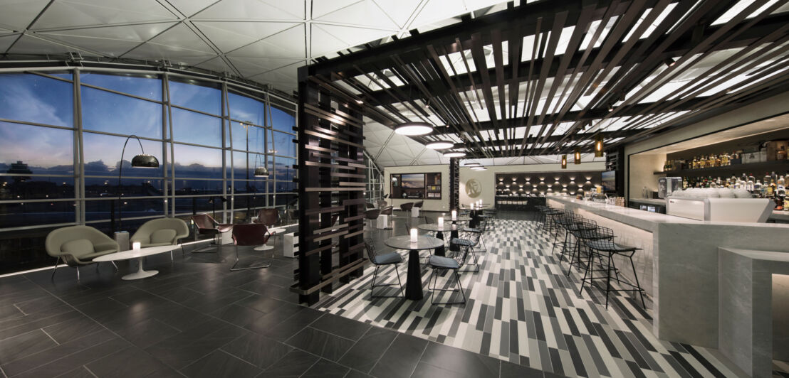 Große, moderne Flughafenlounge mit Bar und Panoramafenster mit Blick aufs Rollfeld