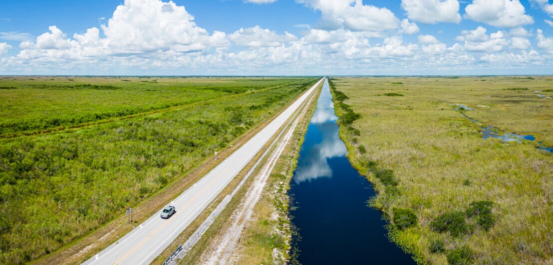 Ein Auto fährt auf einer Straße entlang eines Sumpfes durch den Everglades-Nationalpark.