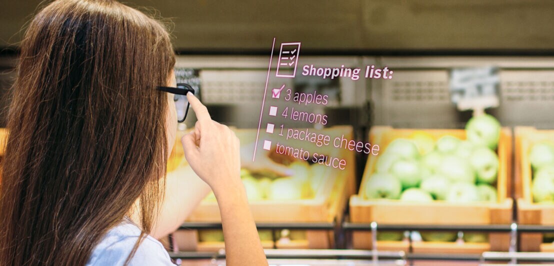 Eine Frau im Supermarkt lässt sich mithilfe des Light Drive Systems von Bosch ihre Einkaufsliste anzeigen