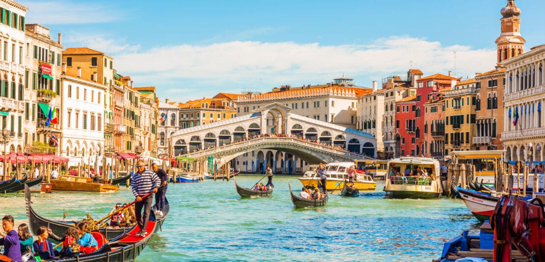 Blick auf die Rialtobrücke über den Canal Grande in Venedig, im Vordergrund mehrere Gondeln