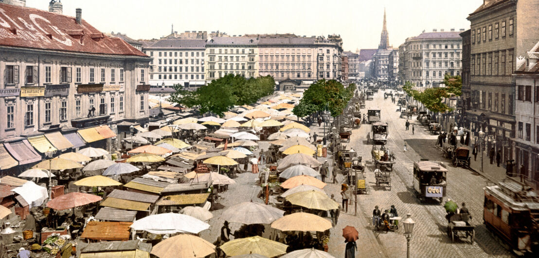 Aufsicht eines innerstädtischen Platzes mit Marktständen; historische, kolorierte Fotoaufnahme.
