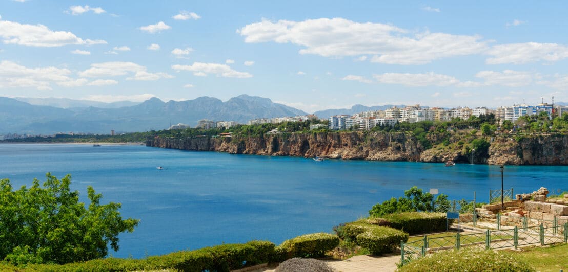 Eine Parkanlage in Antalya. Im Hintergrund liegen das Meer, ein Teil der Stadt und die Berge.