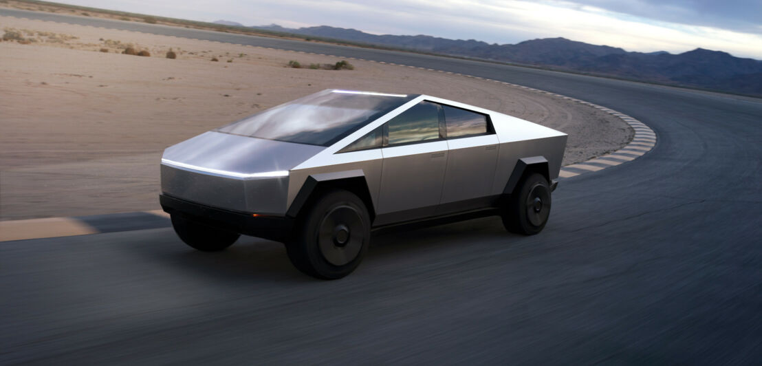 Ein futuristisches Auto von Tesla auf einer Fahrbahn in einer Wüstenlandschaft.