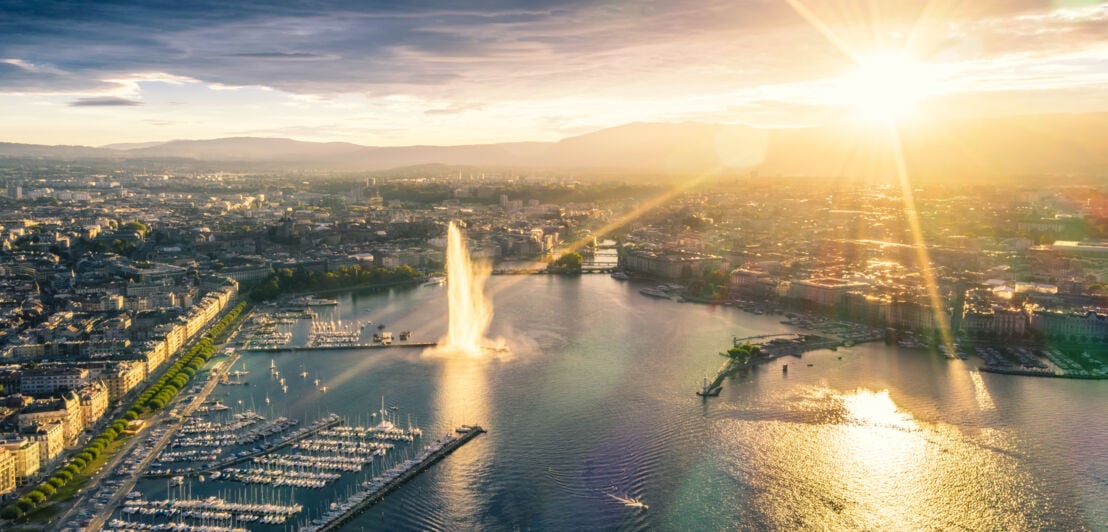 Luftaufnahme der Stadt Genf mit Yachthafen bei Sonnenuntergang.