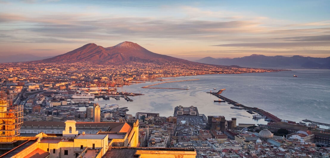 Panorama der Stadt Neapel am Fuße des Vesuvs bei Sonnenuntergang.