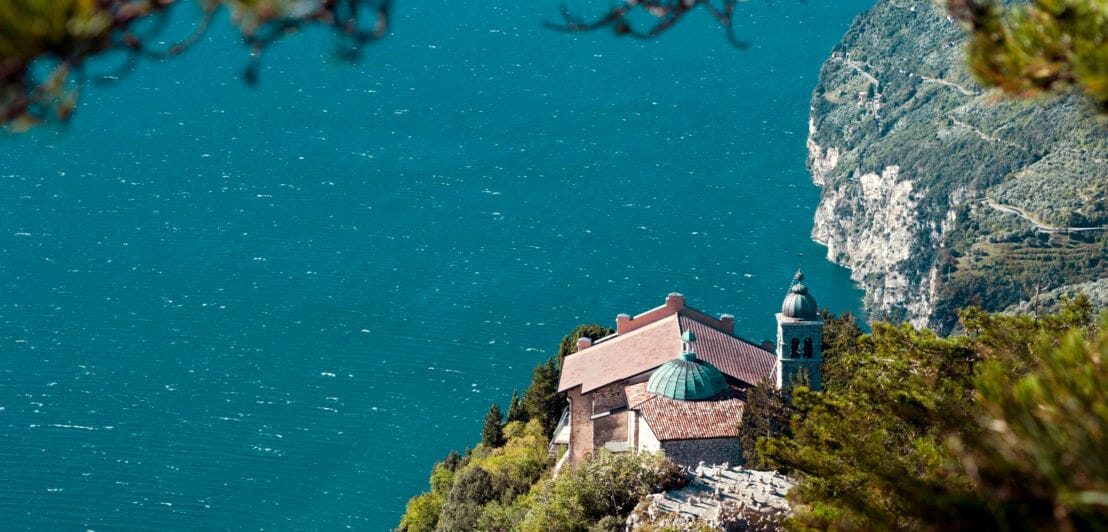 Eine Kirche auf einem Felsvorsprung an einer Steilküste oberhalb eines Sees.