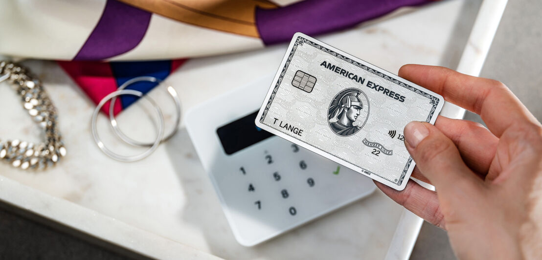 Kontaktlose Zahlung mit einer Amex Platinum Card in einer Modeboutique.