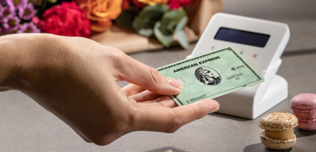 Eine Kundin bezahlt kontaktlos mit der American Express Card an einem Kartenlesegerät.