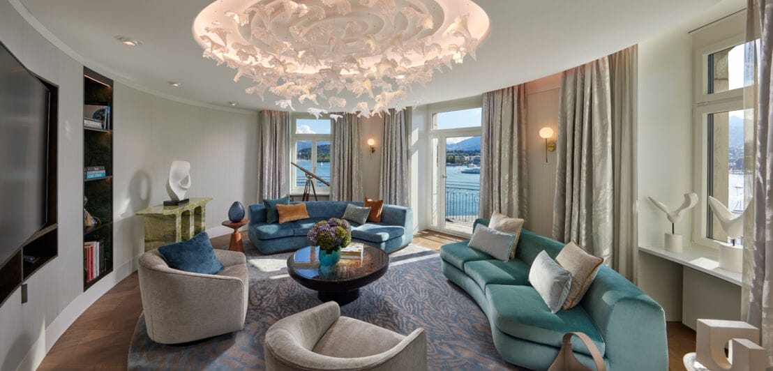 Modernes Wohnzimmer einer luxuriösen Hotelsuite mit runden Wänden und Seeblick.