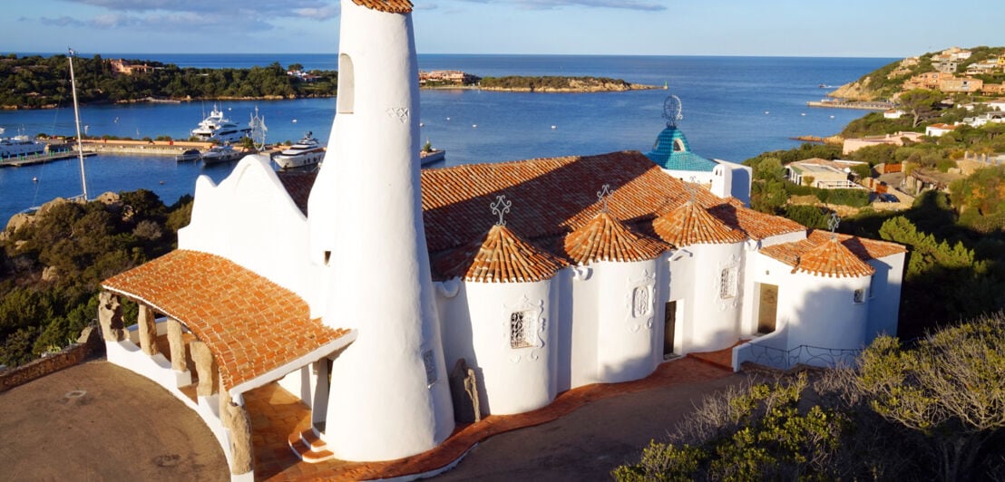 Weiße Kirche mit roten Dachschindeln an der Küste Sardiniens