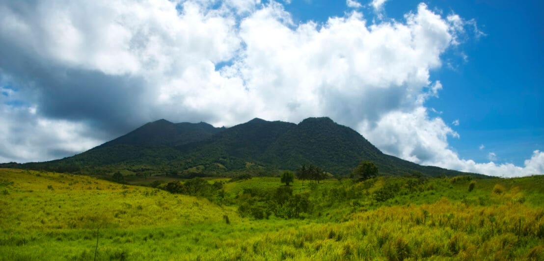 Wolkenverhangener Gipfel des Mount Liamuiga vor grüner Landschaft.