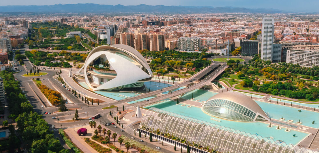 Areal aus mehreren futuristischen Gebäuden, umgeben von einem Wasserbecken, im Zentrum Valencias.