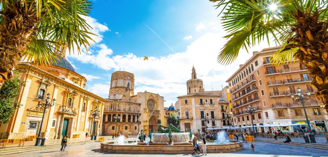 Mediterraner Platz mit Springbrunnen und Kathedrale in der Altstadt Valencias bei Sonnenschein.