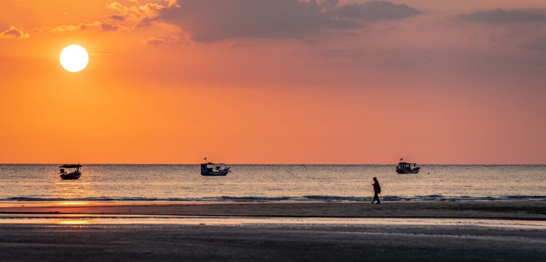 Der Pakarang-Strand auf Khao Lak bei Sonnenuntergang, Boote ankern vor dem Strand.