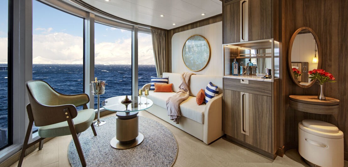 Eine luxuriöse Suite auf einem Schiff mit Panoramablick aufs offene Meer.