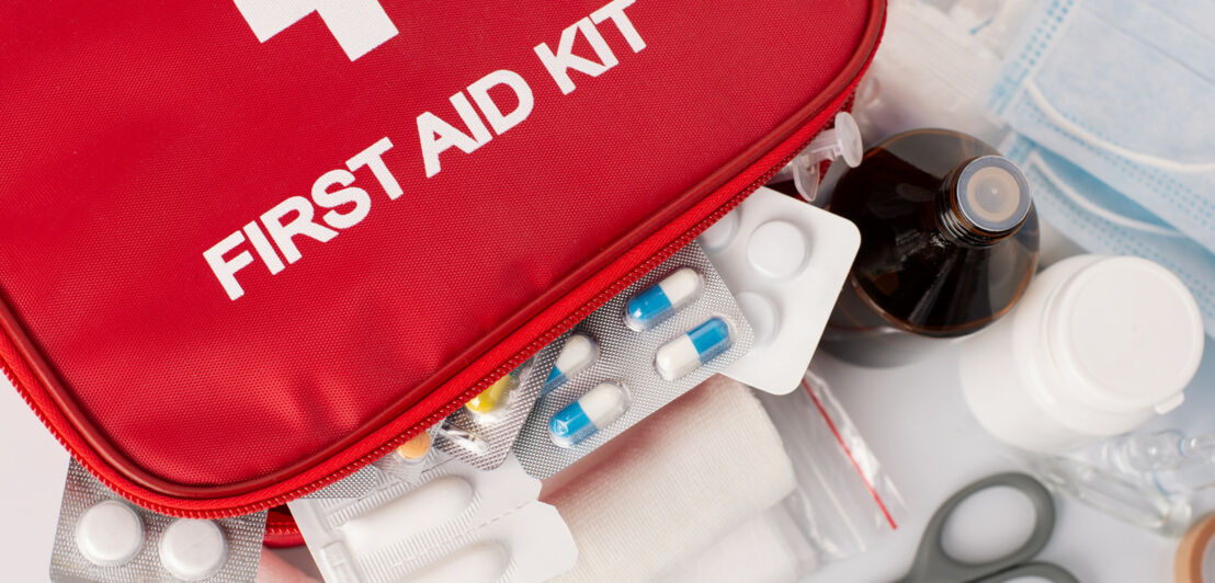 Nahaufnahme einer roten Erste-Hilfe-Tasche mit unterschiedlichen Medikamenten.