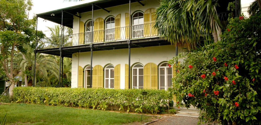 Blick auf das pastellgelbe ehemalige Wohnhaus des Schriftstellers Ernest Hemingway in grüner Umgebung.