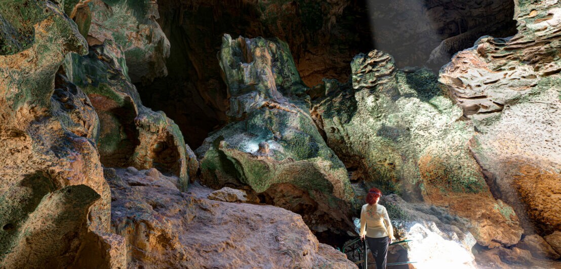 Rückansicht einer Person in einer Höhle. 