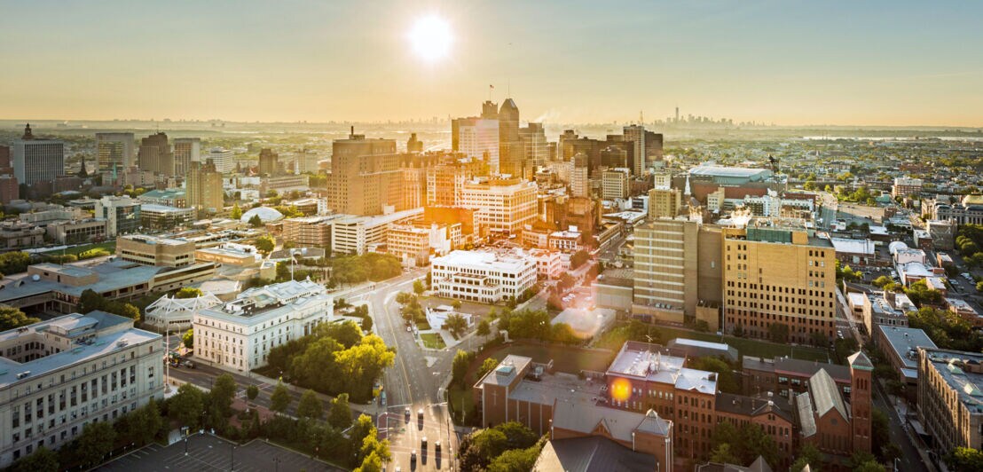 Stadtpanorama von Newark mit Hochhäusern aus der Luftperspektive bei Gegenlicht.
