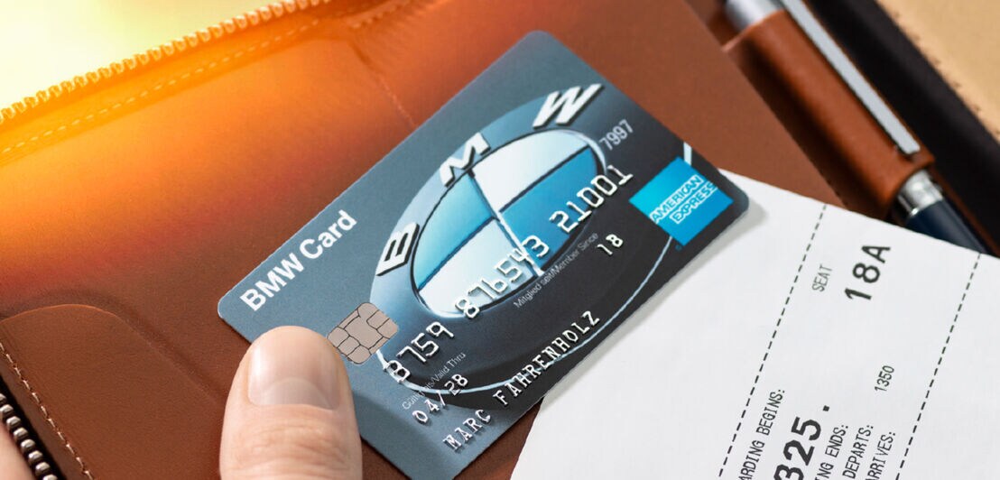 Eine BMW Kreditkarte von American Express auf einem Lederetui, gehalten von einer Hand.