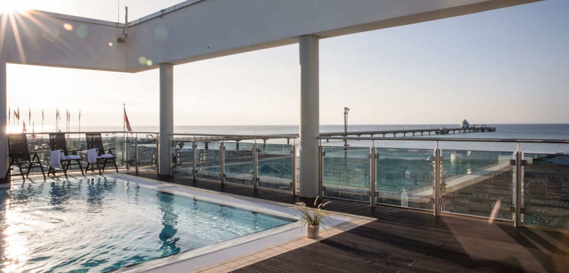 Hotelpool auf einer Dachterrasse mit Blick aufs Meer.