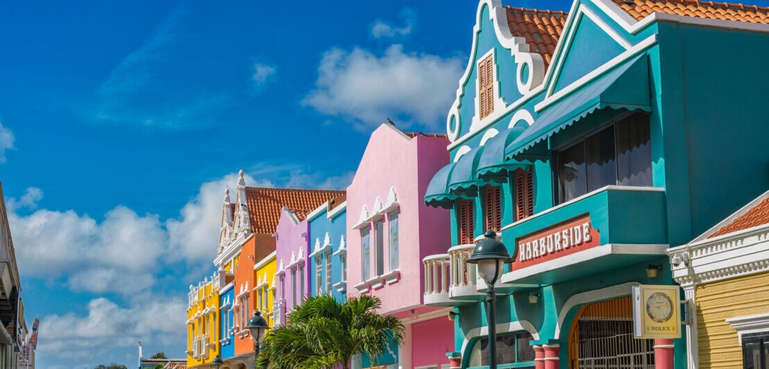 Bunte Häuser im Kolonialstil unter blauem Himmel bei Sonnenschein.