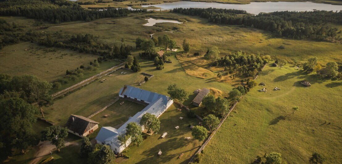 Drohnenaufnahme eines estnischen Herrenhauses umgeben von grüner Landschaft und Seen.