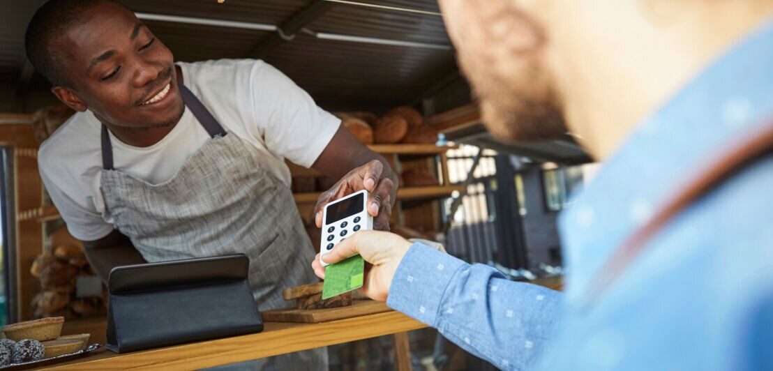 Zahlung mit Kreditkarte bei einem Verkäufer in einem Food Truck.