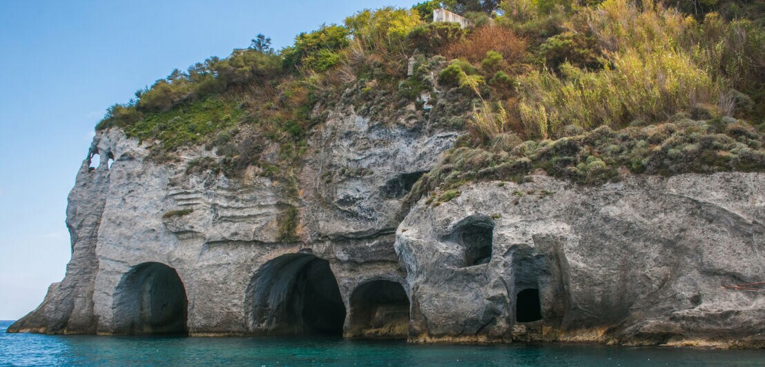 Meereshöhlen in einer steilen Felswand an der Küste von Ponza.