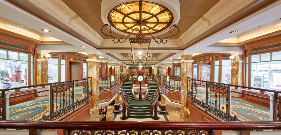 Grand Lobby mit geschwungener Treppe im Art-déco-Stil auf einem Kreuzfahrtschiff.