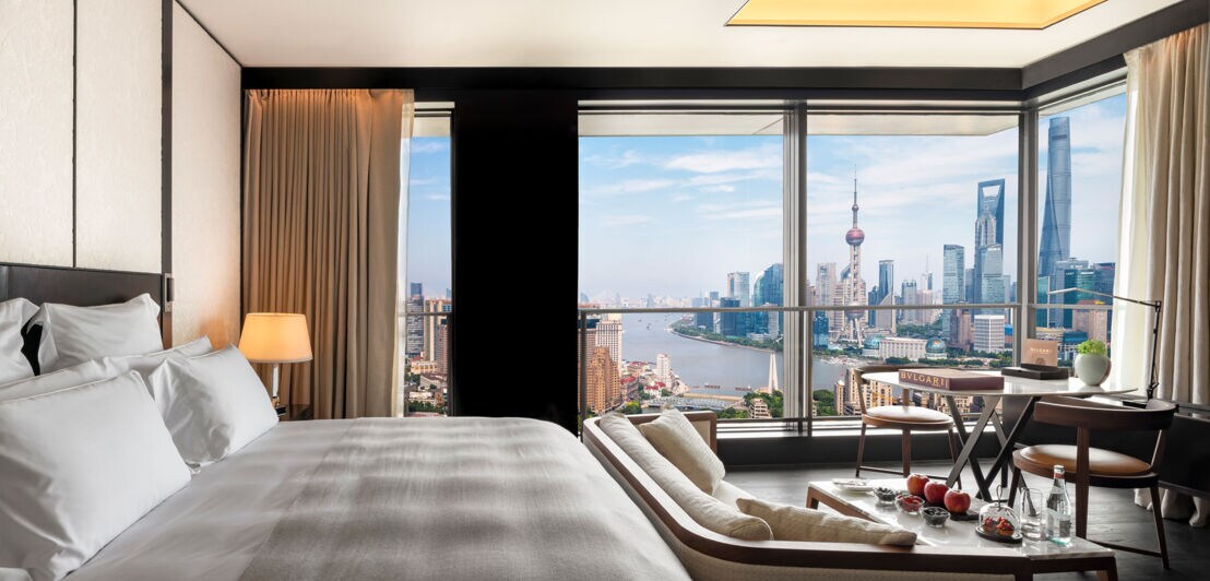 Elegantes Hotelzimmer mit Doppelbett und Panoramablick auf die Skyline von Shanghai.