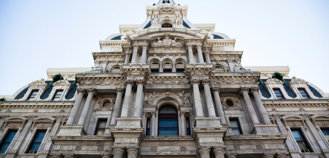 Fassade eines historischen Gebäudes mit Säulen und detaillierter Steinarchitektur, Blick nach oben
